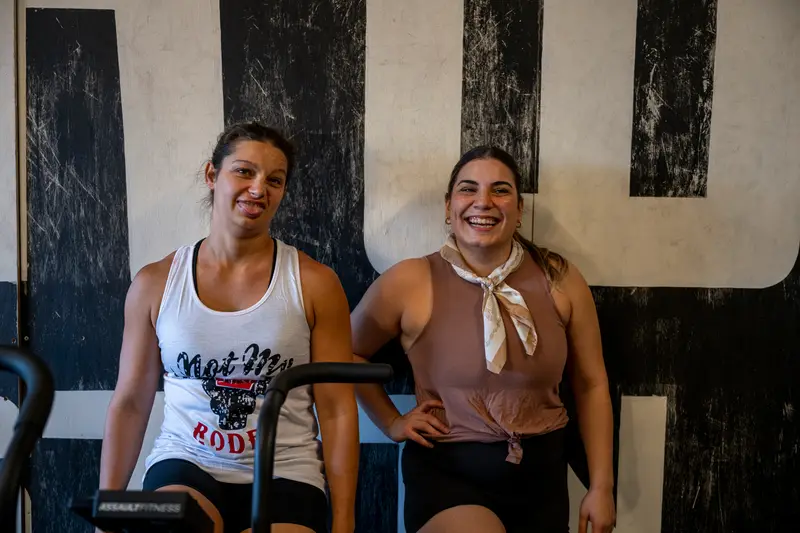 Two Black Wolf members laughing between workouts
