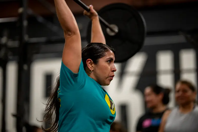 Member locking out a barbell overhead